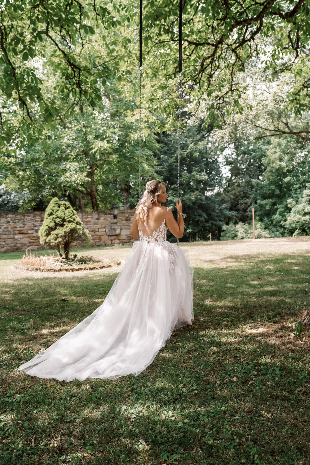 Melissa Herkommer Photography, Hochzeitspaar, die Braut sitzt auf einer Schaukel 