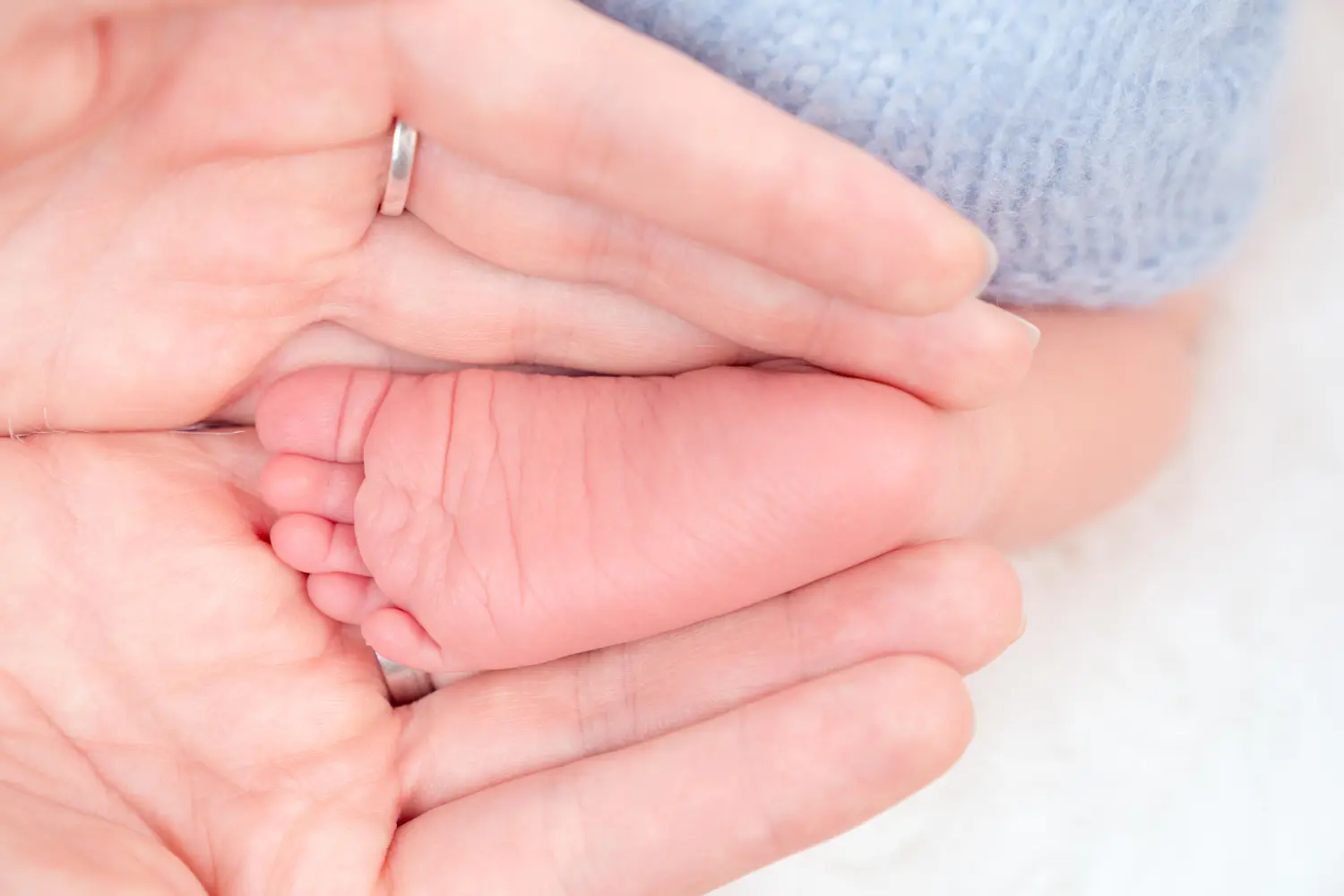 Melissa Herkommer Photography, Neugeborene, Familie Hände halten Baby Fuß