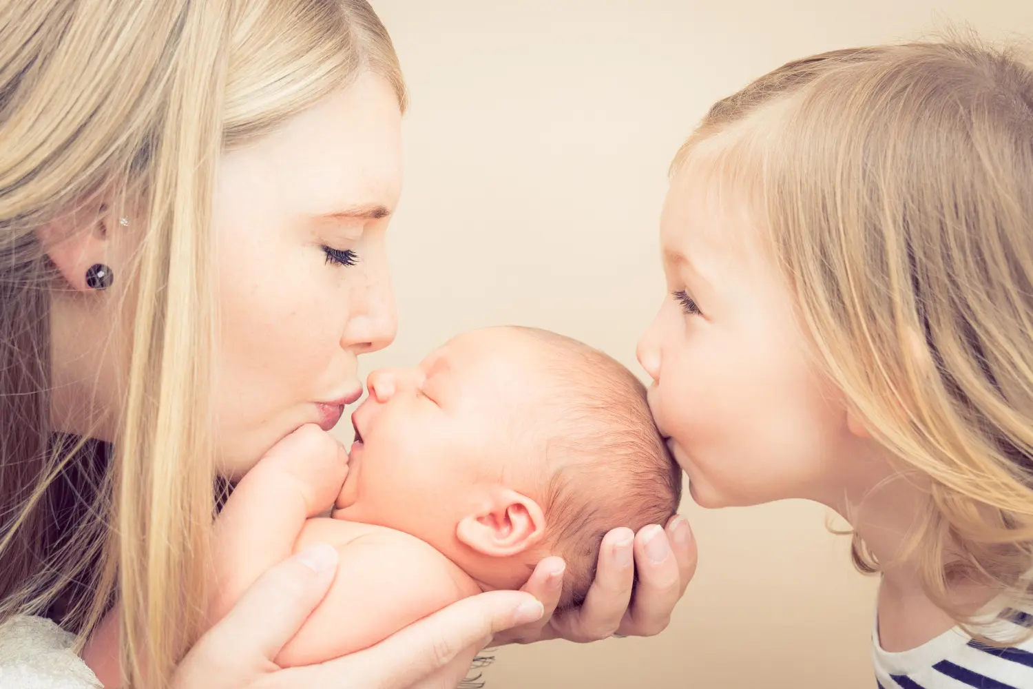 Melissa Herkommer Photography, Neugeborene, Mutter und Tochter küssen ein Neugeborenes