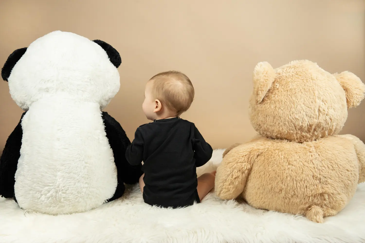 Melissa Herkommer Photography, Baby sitzt zwischen Teddys