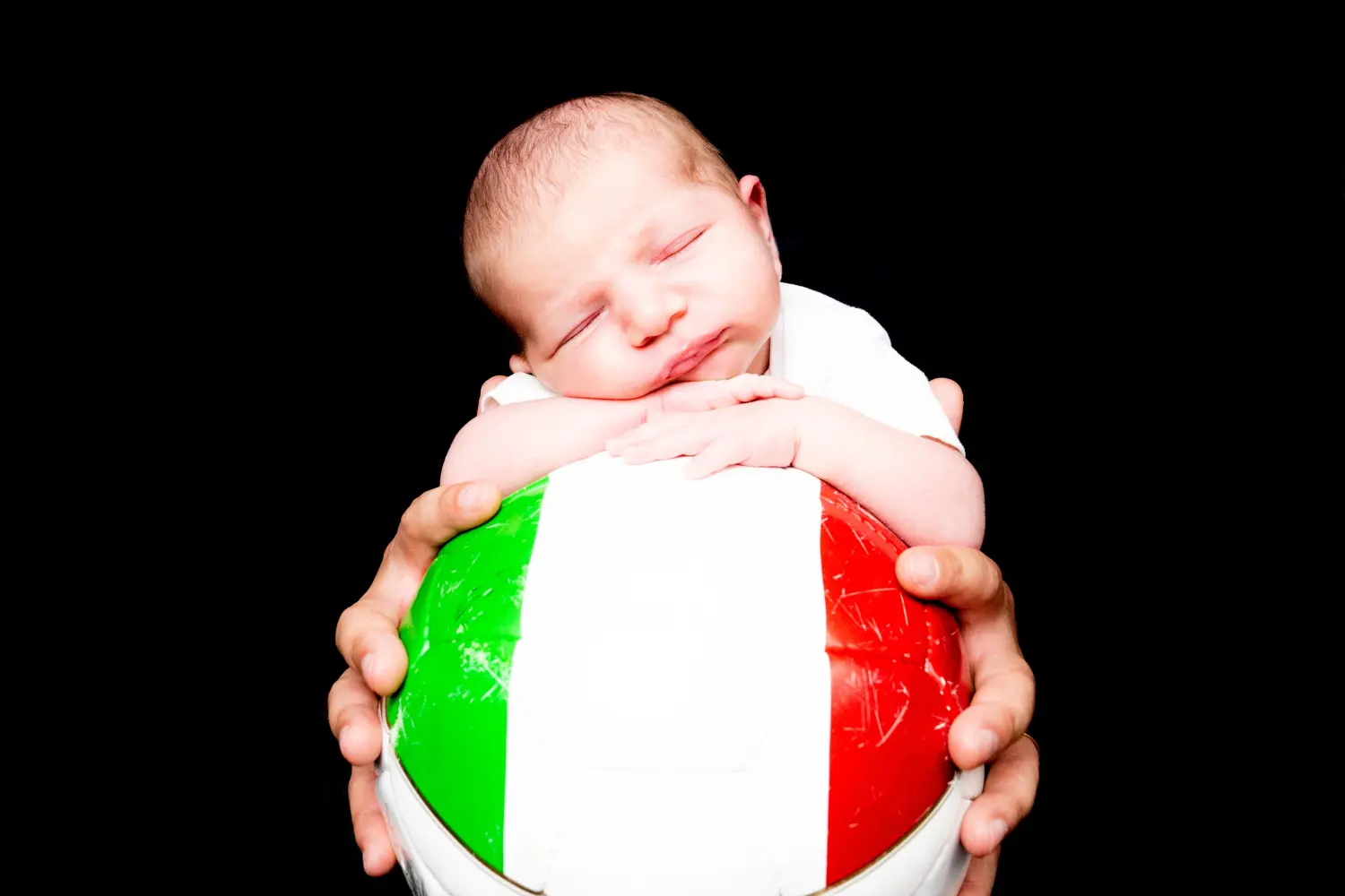 Melissa Herkommer Photography, Neugeborene, Baby's Gesicht ruht auf Fußball