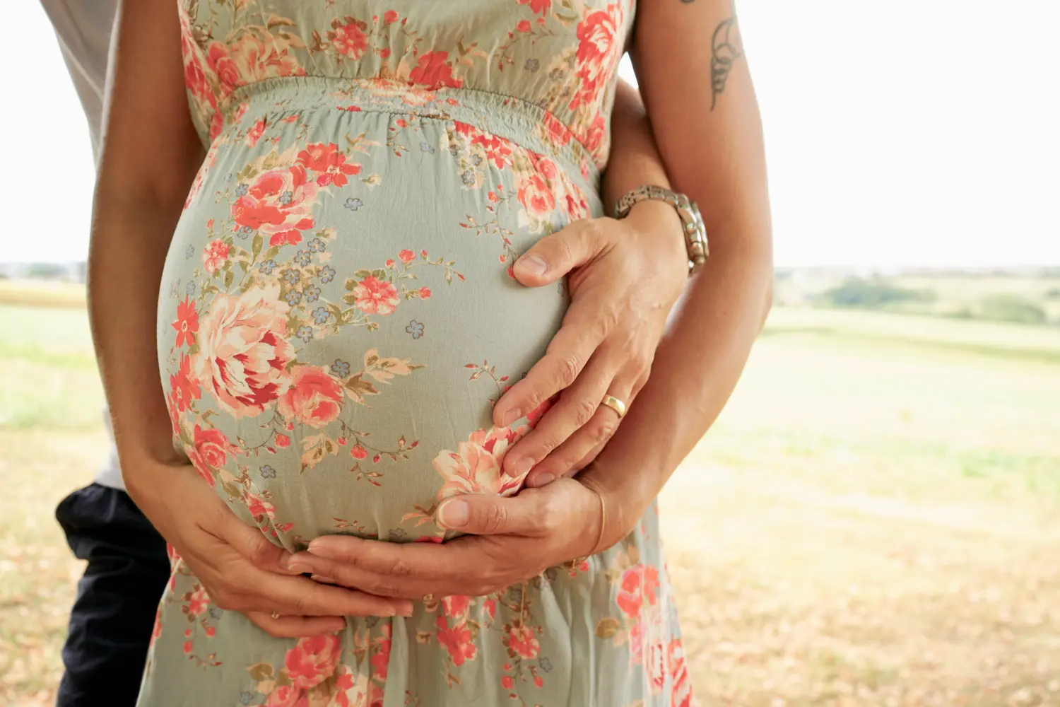 Melissa Herkommer Photography, Babybauch, Paar in der Nähe eines Baumes stehend